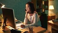 Smiling girl studying remotely from her desktop machine